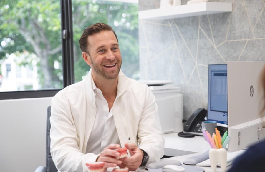 Dr. Ross smiling with orthodontics model