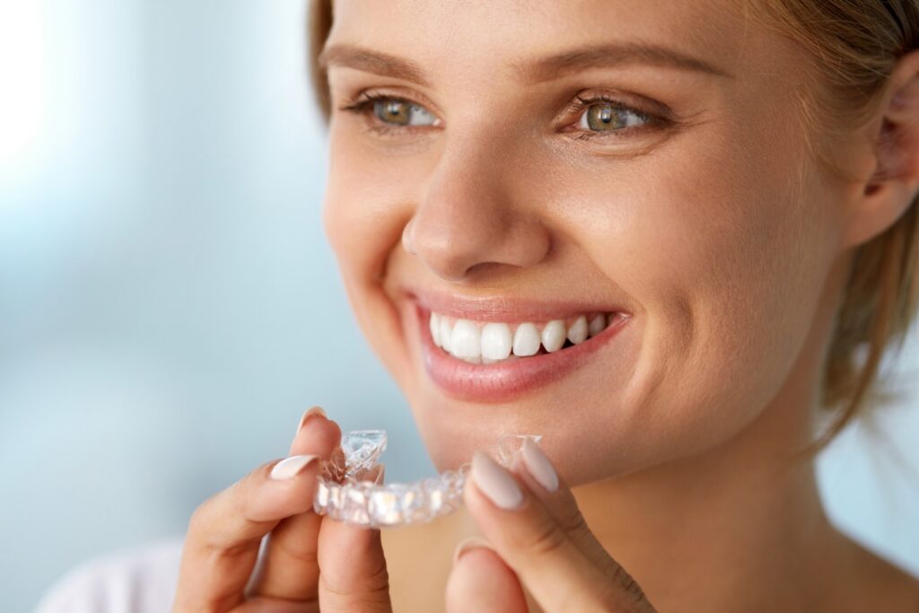 Woman holding Invisalign clear aligner in Coral Gables orthodontic office